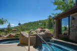 Experience luxury living with this stunning property featuring a private hot tub overlooking a scenic mountain landscape.