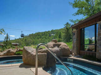 Experience luxury living with this stunning property featuring a private hot tub overlooking a scenic mountain landscape.