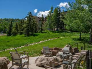 Enjoy the stunning mountain views from this outdoor living space, complete with a fire pit and comfortable seating.