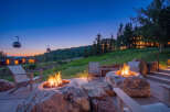 Experience luxury mountain living with this stunning outdoor patio featuring natural stone fire pits and comfortable seating.