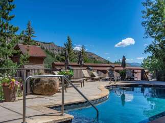 Escape to this mountain oasis featuring a sparkling blue swimming pool and ample lounge chairs for ultimate relaxation.