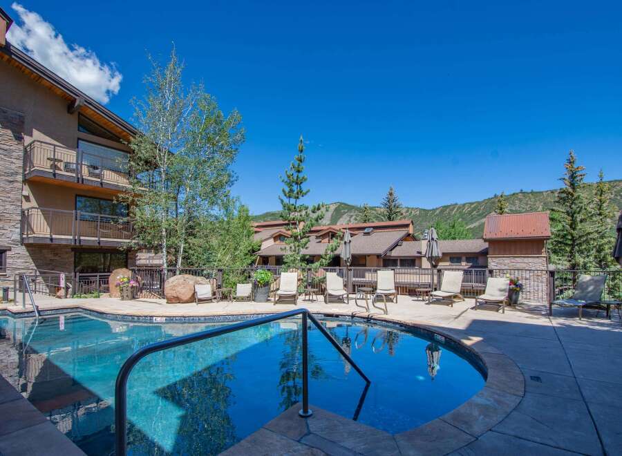 Enjoy a refreshing dip in the sparkling blue pool, surrounded by comfortable lounge chairs perfect for soaking up the sun.