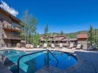 Enjoy a refreshing dip in the sparkling blue pool, surrounded by comfortable lounge chairs perfect for soaking up the sun.