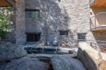 Experience ultimate relaxation in this luxurious outdoor spa, surrounded by natural stone and lush greenery.