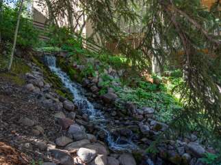 Experience serene living with this charming property featuring a beautiful natural rock waterfall cascading down a lush hillside.