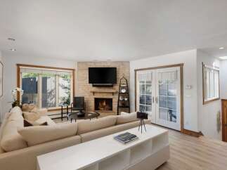 Experience cozy living in this inviting living room, featuring a stunning stone fireplace as the focal point.