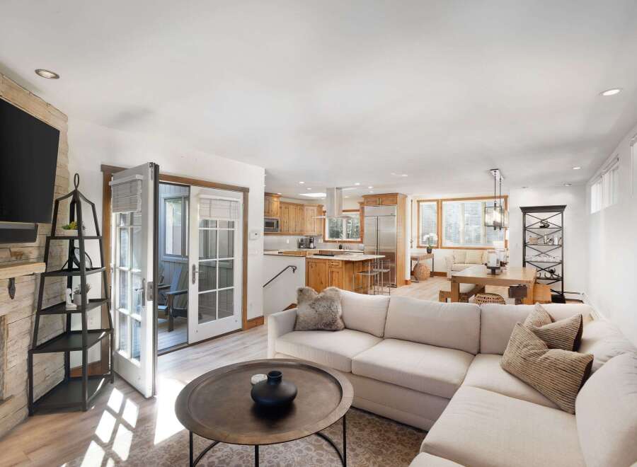 Experience modern living in this open-concept home featuring a spacious living area with a stone fireplace and a sleek entertainment center.