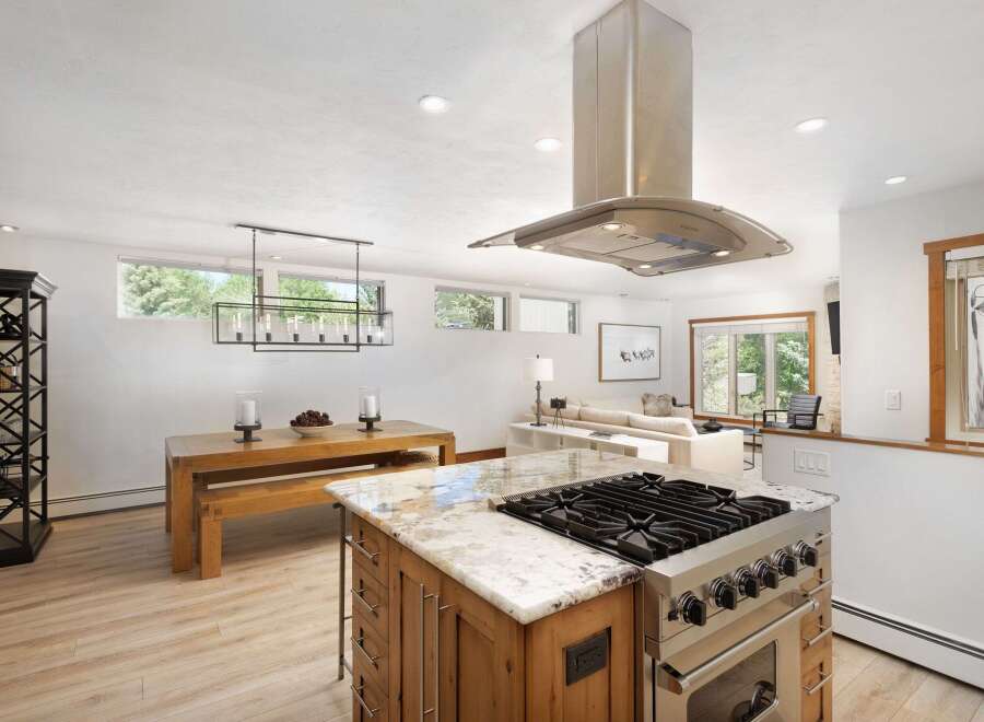 This spacious open-concept kitchen and dining area features a large island with a professional-grade gas range, perfect for culinary enthusiasts.