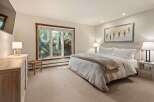 Experience serene mountain living in this beautifully appointed bedroom, featuring a plush king-sized bed with crisp white linens and a cozy throw.