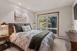 Experience serene mountain living in this charming bedroom, featuring a comfortable queen-size bed adorned with a nature-inspired duvet and plush pillows.