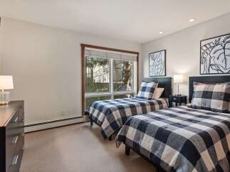 This charming bedroom features two twin beds with classic black and white buffalo check bedding, perfect for a cozy guest room or shared children's space.