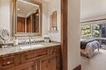 This charming bathroom features a double vanity with a granite countertop and a wooden cabinet base, complemented by a large ornate mirror.