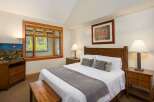 Experience comfort and style in this beautifully appointed bedroom, featuring a plush queen-size bed adorned with crisp white linens and decorative pillows.