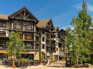 Discover luxury mountain living in this stunning property, featuring a modern alpine architectural style with exposed timber beams and stone accents.