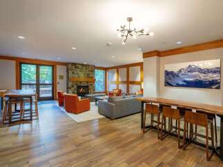 Experience ultimate comfort and style in this inviting living space, featuring a cozy stone fireplace and plush seating arrangements perfect for relaxation.
