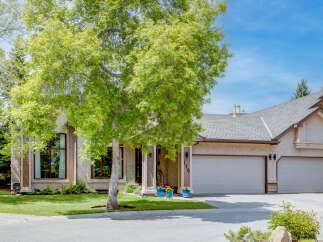 This stunning home features a beautiful stucco exterior and a spacious three-car garage, perfect for any car enthusiast.