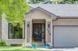 Charming home with a welcoming covered entryway featuring decorative pillars and exterior lighting.