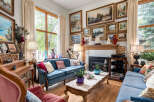 Step into this elegantly furnished living room, featuring a plush blue velvet sofa and a matching loveseat, perfect for relaxing.