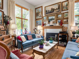 Step into this elegantly furnished living room, featuring a plush blue velvet sofa and a matching loveseat, perfect for relaxing.