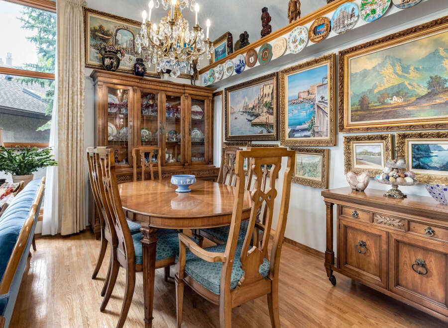 Experience elegant dining in this beautifully appointed room, featuring a large wooden dining table with upholstered chairs, perfect for hosting gatherings.