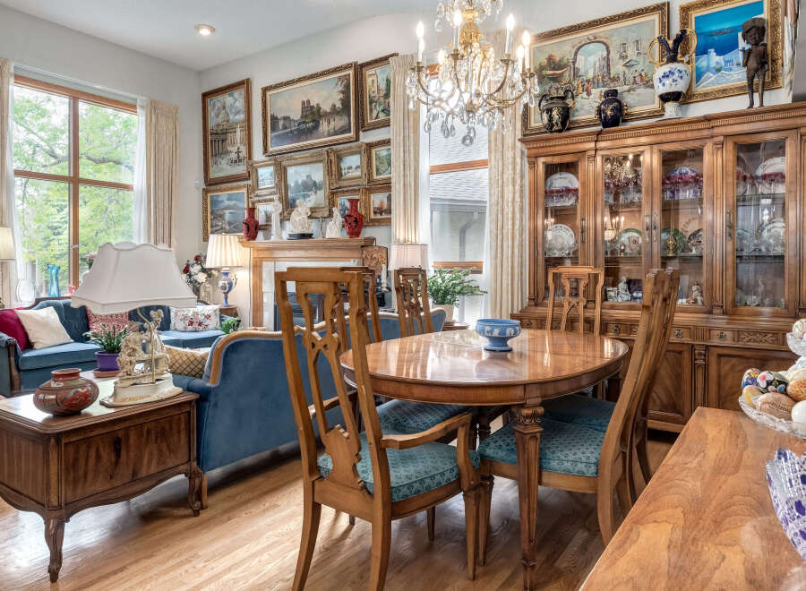 Step into this elegant dining and living area, featuring a sophisticated blue velvet sofa and a charming wooden dining set perfect for family gatherings.