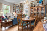 Step into this elegant dining and living area, featuring a sophisticated blue velvet sofa and a charming wooden dining set perfect for family gatherings.