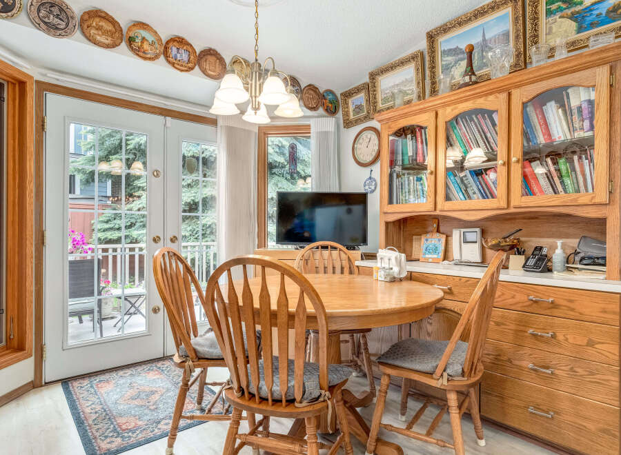 Enjoy casual dining in this charming eat-in kitchen, featuring a round wooden table with four chairs perfect for family meals.