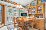 Enjoy casual dining in this charming eat-in kitchen, featuring a round wooden table with four chairs perfect for family meals.