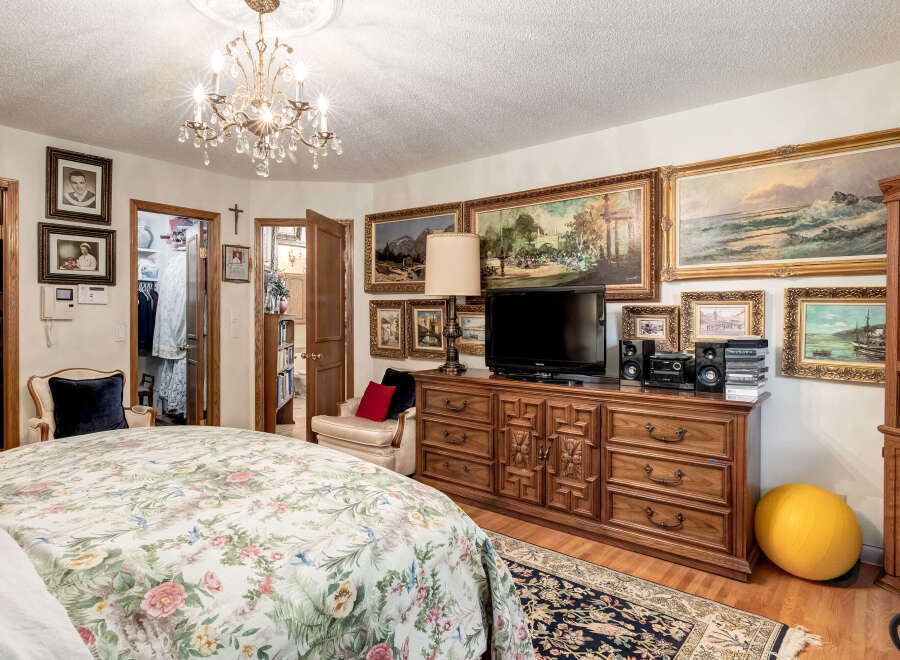 Step into this charming bedroom, featuring a luxurious floral comforter on a spacious bed, perfect for relaxation.