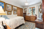 This charming bedroom features a comfortable bed adorned with a textured white quilt and a soft blue throw, complemented by a decorative fringed lamp.
