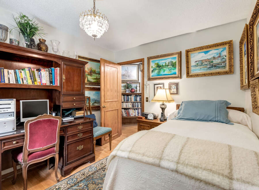 This charming bedroom offers a perfect blend of comfort and functionality, featuring a cozy bed adorned with a light blue pillow and a textured throw.