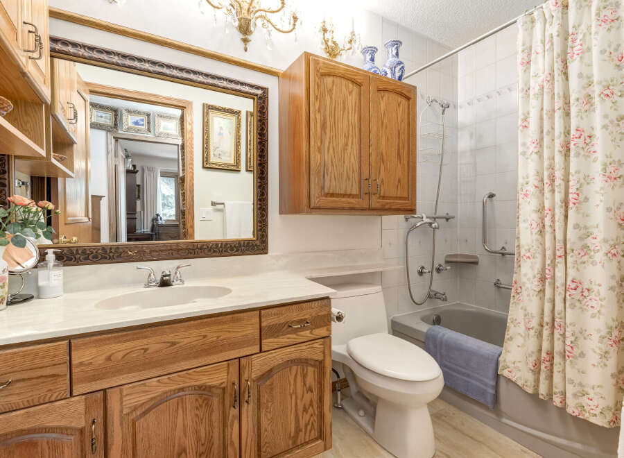 This charming bathroom features a spacious vanity with ample storage and a marble countertop.