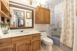 This charming bathroom features a spacious vanity with ample storage and a marble countertop.