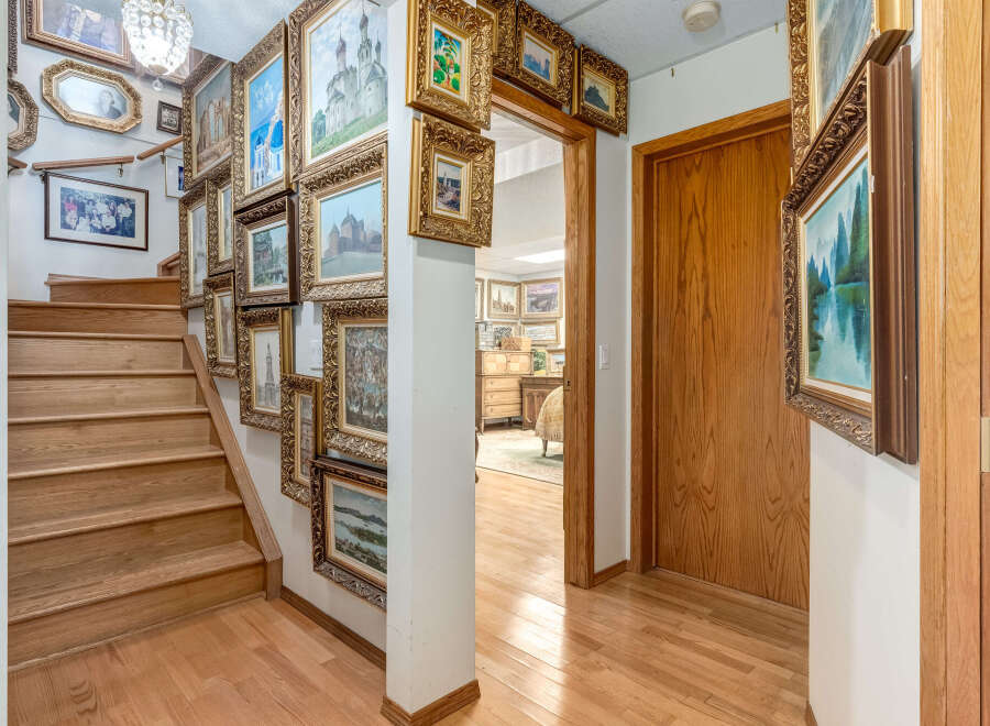 Step into a home adorned with a stunning collection of framed artwork, creating a gallery-like ambiance throughout the entryway and staircase.