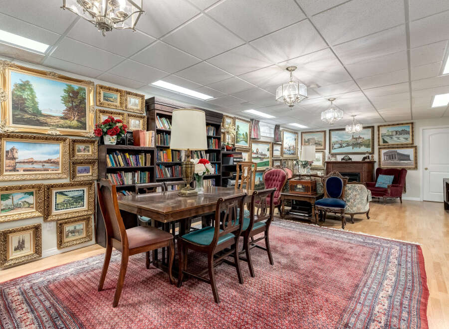 Step into this beautifully appointed room, featuring a large wooden dining table perfect for gatherings, surrounded by an impressive collection of framed artwork adorning the walls.