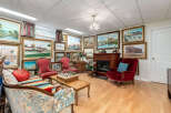 Step into this uniquely decorated living room, featuring an impressive collection of framed artwork adorning the walls, creating a gallery-like atmosphere.