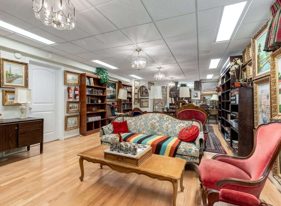 Step into this charming living space, featuring a cozy floral sofa adorned with a vibrant, hand-knitted throw and a classic chess set ready for play.