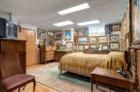 This charming bedroom features a cozy bed adorned with a decorative yellow quilt, perfect for relaxation.