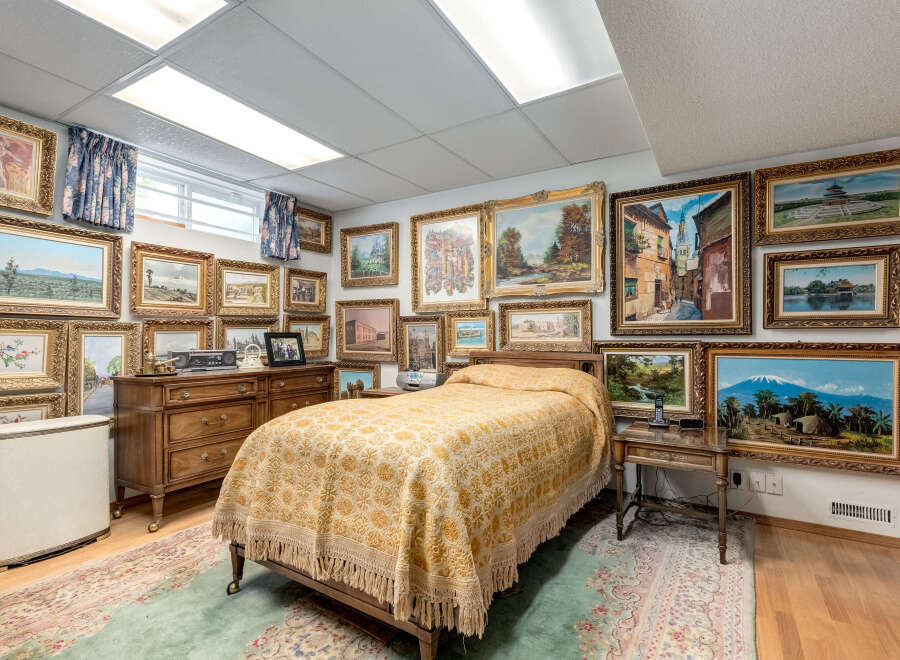 This charming bedroom features a cozy bed adorned with a beautiful yellow patterned quilt, perfect for a restful night's sleep.