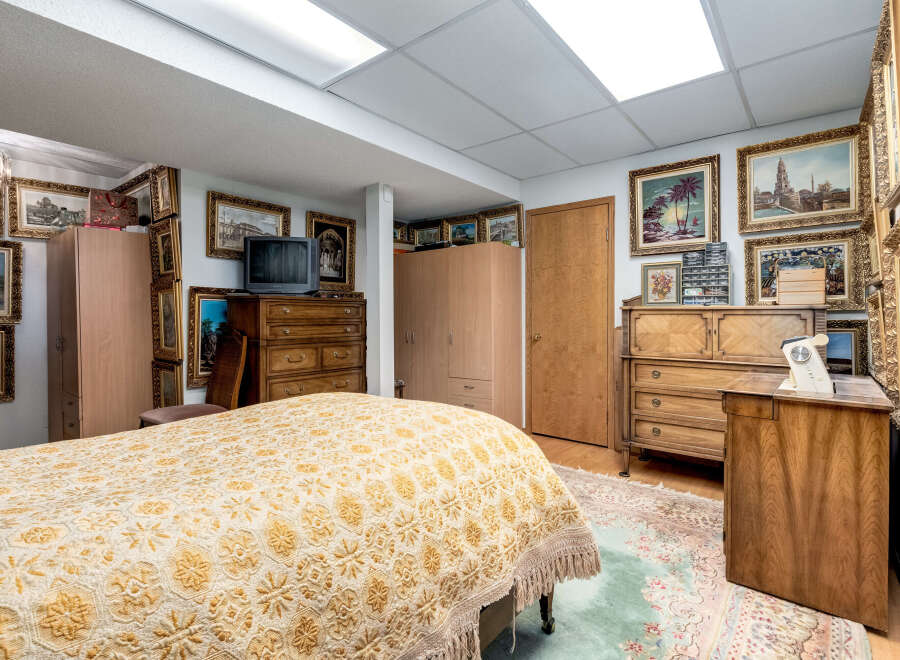 This charming bedroom features a large bed with a decorative yellow and white patterned quilt, creating a cozy and inviting atmosphere.