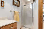 This bathroom features a spacious shower with frosted glass doors, perfect for privacy.