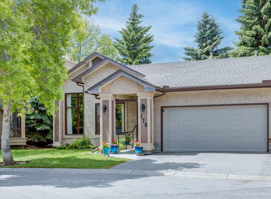 Charming single-family home featuring a stucco exterior and a welcoming covered entryway with decorative columns.