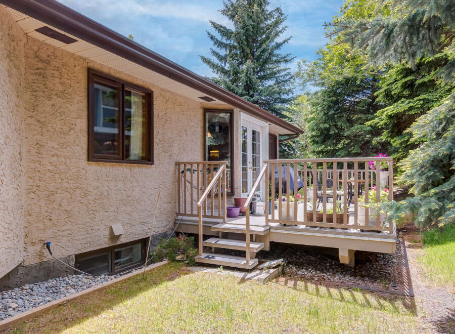Enjoy outdoor living on this charming deck, perfect for entertaining or relaxing amidst lush greenery.