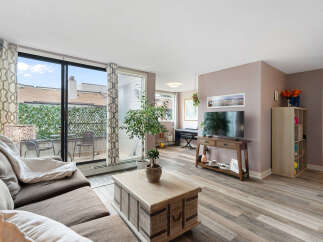 Bright and airy living room featuring a comfortable sectional sofa, a stylish coffee table, and a large TV for entertainment.