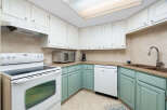 This charming kitchen features a white electric range with a smooth top and a built-in microwave above.