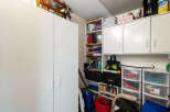 This spacious storage area offers ample room for all your belongings, featuring large white cabinets and open shelving units.