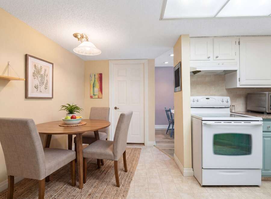 This charming dining area features a round wooden table with four upholstered chairs, perfect for intimate meals.
