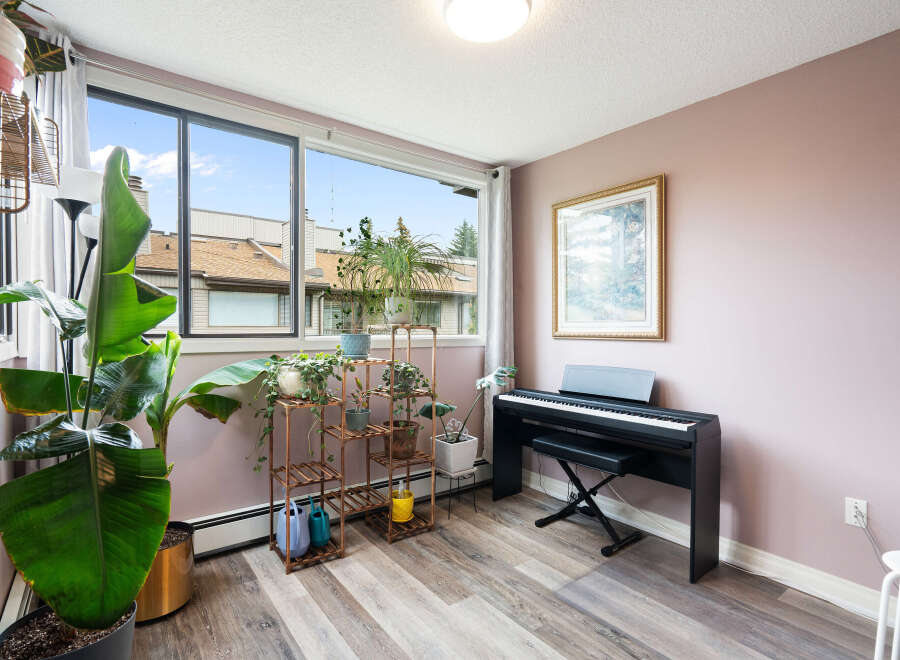 Bright and airy living space featuring a digital piano and a large window with scenic views.