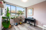 Bright and airy living space featuring a digital piano and a large window with scenic views.