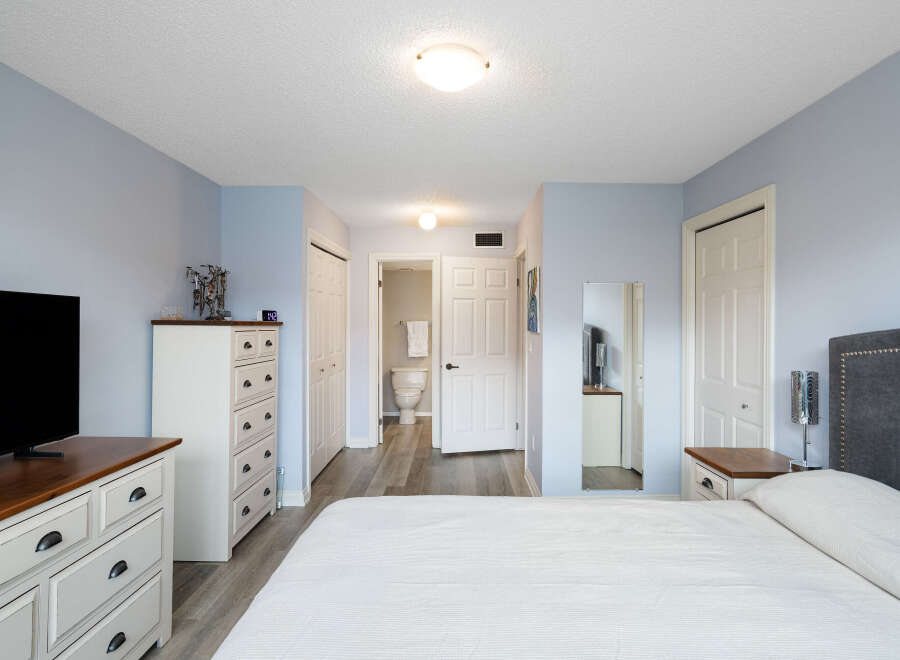 Discover comfort and convenience in this inviting bedroom, featuring a spacious layout and a private ensuite bathroom accessible through a charming doorway.